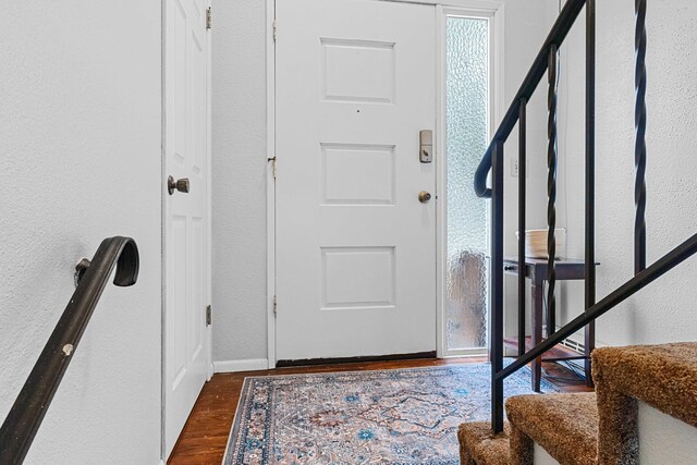 122 E Circle Dr, Newport, WA 99156 - foyer entrance featuring stairway, a textured wall, dark wood-style flooring, and baseboards