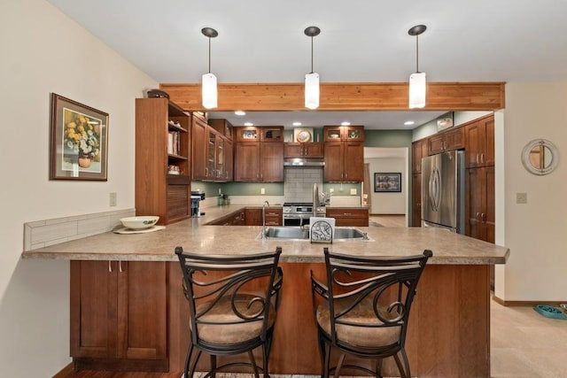 536 E 1st Ave, Colville, WA 99114 - kitchen featuring appliances with stainless steel finishes, a peninsula, under cabinet range hood, hanging light fixtures, and beamed ceiling