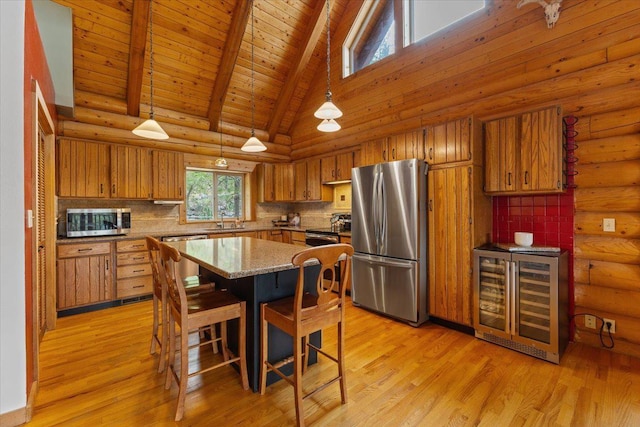 3947 N Deer Lake Rd, Loon Lake, WA 99148 - kitchen featuring appliances with stainless steel finishes, beverage cooler, brown cabinets, a sink, and high vaulted ceiling