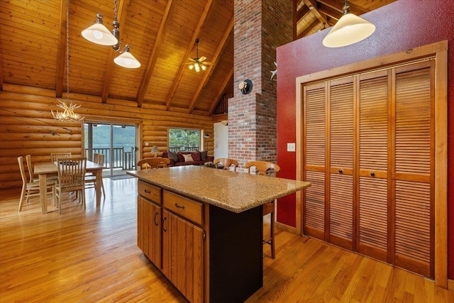 3947 N Deer Lake Rd, Loon Lake, WA 99148 - kitchen with high vaulted ceiling, rustic walls, wood ceiling with exposed beams, light wood finished floors, and pendant lighting