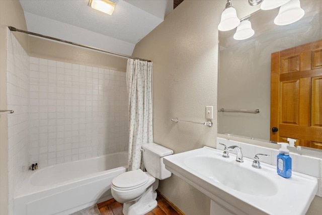 3947 N Deer Lake Rd, Loon Lake, WA 99148 - bathroom featuring shower / bathtub combination with curtain, toilet, a sink, wood finished floors, and a textured wall