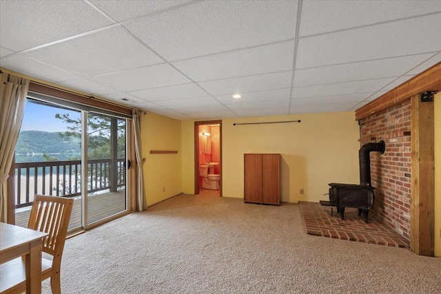 3947 N Deer Lake Rd, Loon Lake, WA 99148 - unfurnished living room featuring a wood stove, carpet floors, and a drop ceiling