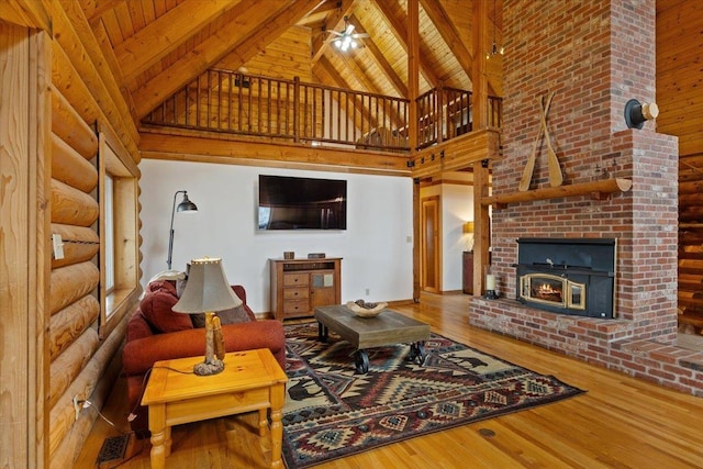 3947 N Deer Lake Rd, Loon Lake, WA 99148 - living room with high vaulted ceiling, wood finished floors, wood ceiling with exposed beams, ceiling fan, and a fireplace
