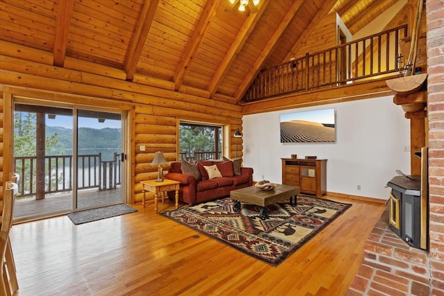 3947 N Deer Lake Rd, Loon Lake, WA 99148 - living room featuring high vaulted ceiling, a wood stove, wooden ceiling with exposed beams, baseboards, and wood finished floors