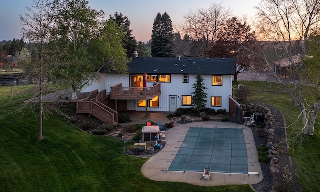10409 E Palouse Hwy, Valleyford, WA 99036 - back of property at dusk featuring stairway, a wooden deck, a lawn, a patio, and a covered pool