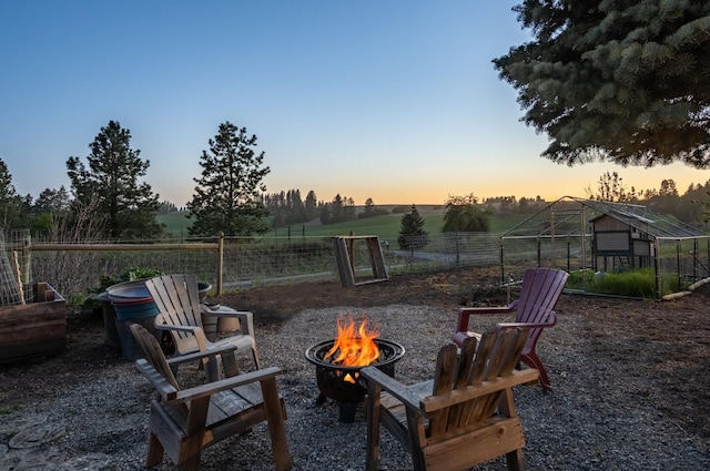10409 E Palouse Hwy, Valleyford, WA 99036 - yard at dusk with an outdoor fire pit, an exterior structure, an outbuilding, and a view of rural / pastoral area