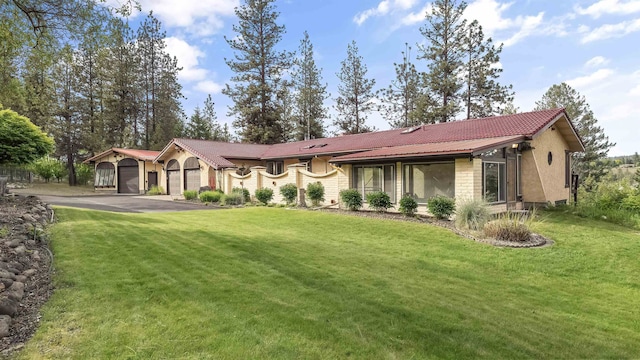 13110 W Charles Rd, Nine Mile Falls, WA 99026 - view of front of house featuring a garage, a front lawn, asphalt driveway, and stucco siding