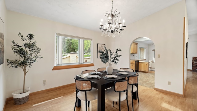 13110 W Charles Rd, Nine Mile Falls, WA 99026 - dining space with arched walkways, light wood-style floors, a chandelier, and baseboards