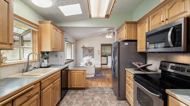 13110 W Charles Rd, Nine Mile Falls, WA 99026 - kitchen with stainless steel appliances, a sink, lofted ceiling, a skylight, and plenty of natural light