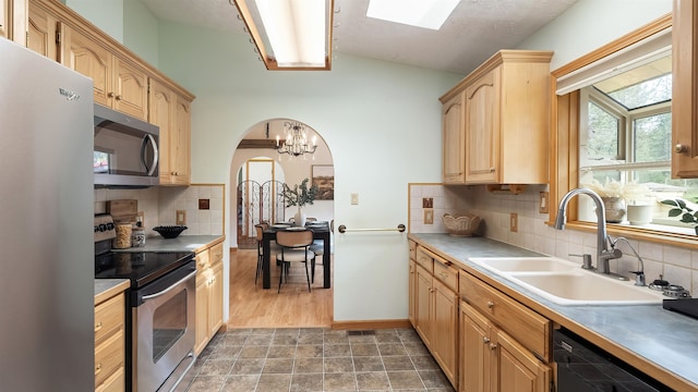 13110 W Charles Rd, Nine Mile Falls, WA 99026 - kitchen with stainless steel appliances, a sink, backsplash, arched walkways, and a chandelier