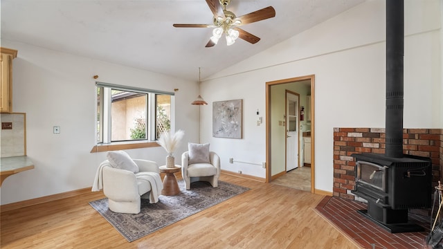 13110 W Charles Rd, Nine Mile Falls, WA 99026 - sitting room with a wood stove, vaulted ceiling, light wood-type flooring, baseboards, and a ceiling fan