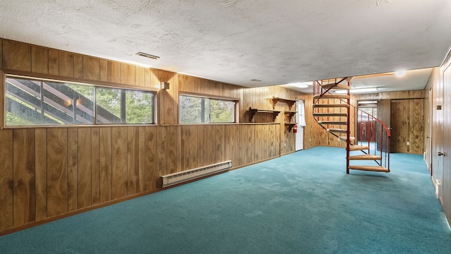 13110 W Charles Rd, Nine Mile Falls, WA 99026 - basement with a baseboard radiator, wood walls, carpet, stairs, and a textured ceiling