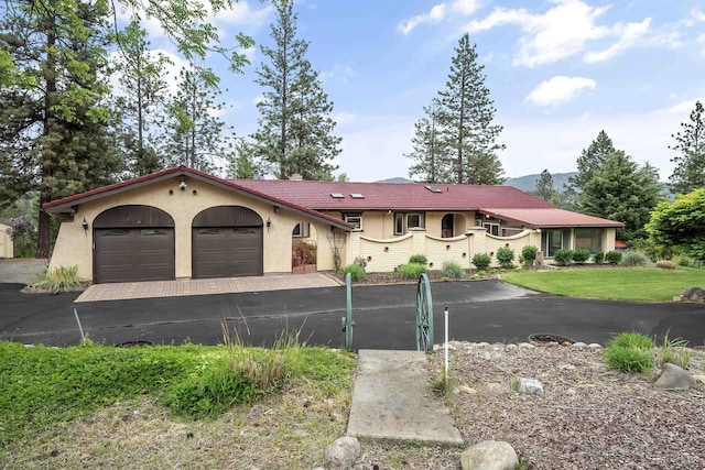 13110 W Charles Rd, Nine Mile Falls, WA 99026 - mediterranean / spanish house with stucco siding, an attached garage, and a tiled roof