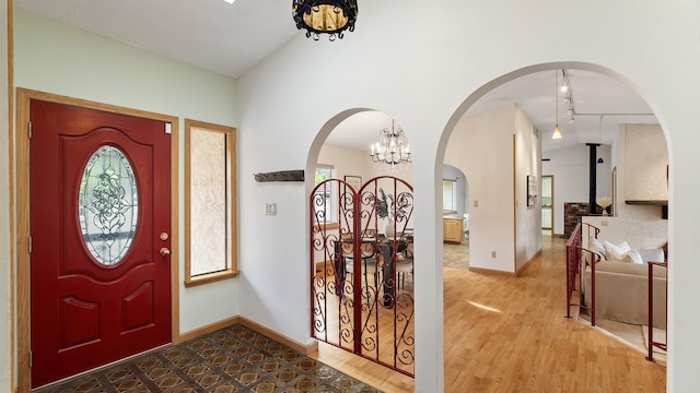 13110 W Charles Rd, Nine Mile Falls, WA 99026 - foyer featuring a chandelier, track lighting, arched walkways, baseboards, and wood finished floors