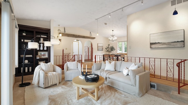 13110 W Charles Rd, Nine Mile Falls, WA 99026 - living room featuring arched walkways, vaulted ceiling, and a chandelier