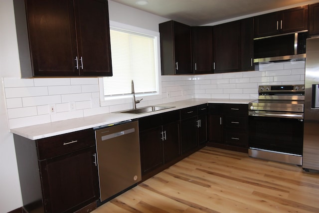 117 5th Ave, Cusick, WA 99119 - kitchen featuring appliances with stainless steel finishes, a sink, light wood-type flooring, light countertops, and backsplash