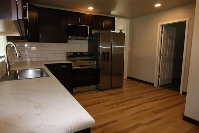 117 5th Ave, Cusick, WA 99119 - kitchen with appliances with stainless steel finishes, a sink, tasteful backsplash, light countertops, and light wood-type flooring