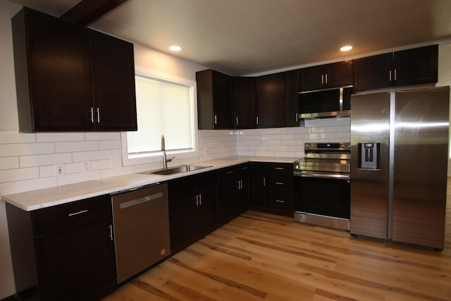 117 5th Ave, Cusick, WA 99119 - kitchen with stainless steel appliances, a sink, light wood-style flooring, light countertops, and decorative backsplash