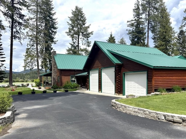 812 Levitch Rd, Newport, WA 99156 - view of home's exterior featuring a chimney, metal roof, a detached garage, a yard, and a mountain view