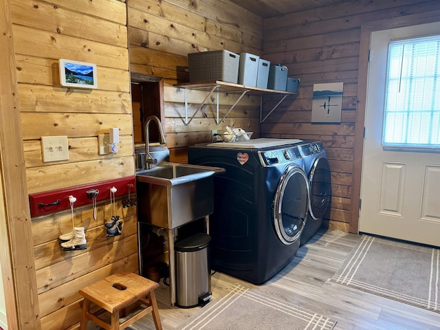 812 Levitch Rd, Newport, WA 99156 - washroom featuring washing machine and dryer, wooden walls, and light wood finished floors