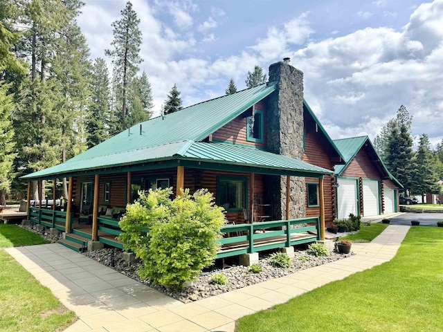 812 Levitch Rd, Newport, WA 99156 - view of home's exterior featuring a chimney, a garage, metal roof, a lawn, and covered porch