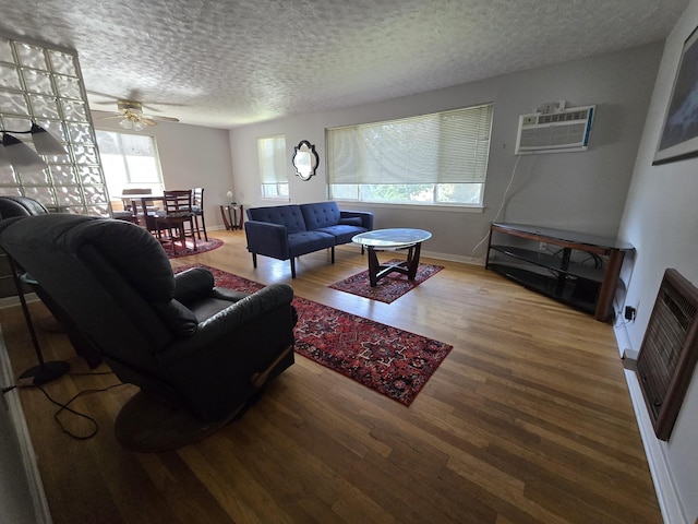 405 S Coeur Dalene St Unit 11, Spokane, WA 99201 - living area with wood finished floors, a wall mounted air conditioner, a ceiling fan, a textured ceiling, and baseboards
