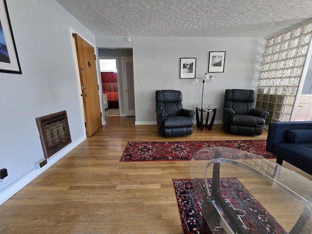 405 S Coeur Dalene St Unit 11, Spokane, WA 99201 - living room with heating unit, a textured ceiling, wood finished floors, and baseboards