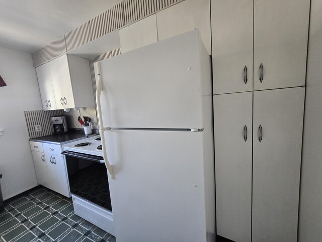 405 S Coeur Dalene St Unit 11, Spokane, WA 99201 - kitchen featuring white appliances, dark countertops, and dark tile patterned floors