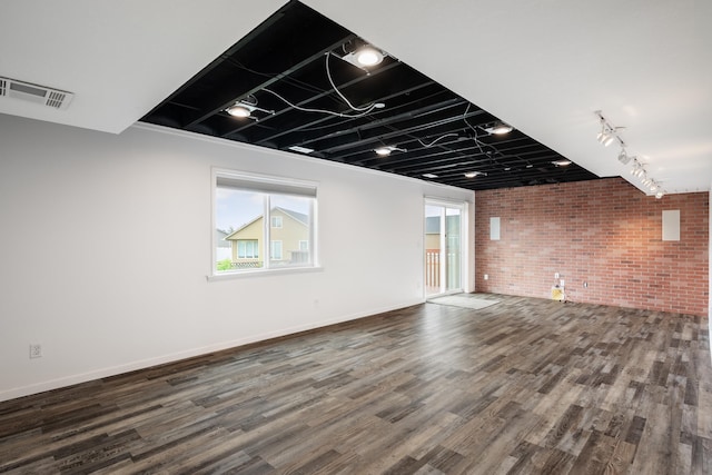 8566 N Oak St, Spokane, WA 99208 - unfurnished living room featuring brick wall, wood finished floors, healthy amount of natural light, and track lighting
