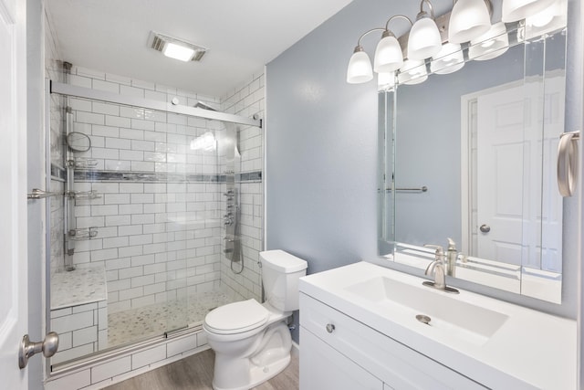 8566 N Oak St, Spokane, WA 99208 - bathroom featuring a stall shower, toilet, vanity, and wood finished floors