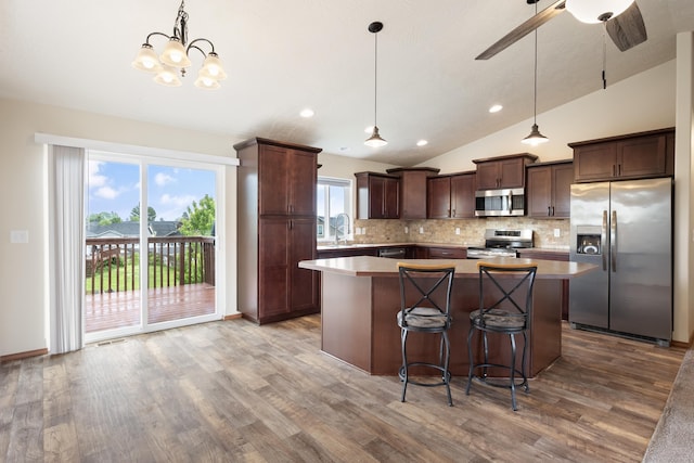 8566 N Oak St, Spokane, WA 99208 - kitchen featuring appliances with stainless steel finishes, dark brown cabinetry, tasteful backsplash, a center island, and lofted ceiling