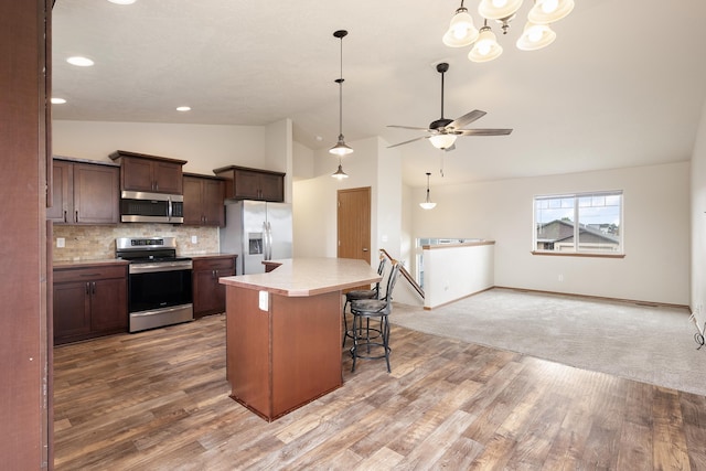 8566 N Oak St, Spokane, WA 99208 - kitchen with stainless steel appliances, light countertops, light wood finished floors, a kitchen island, and tasteful backsplash