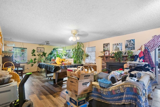 2029 E Sharp Ave, Spokane, WA 99202 - living area with wood finished floors, ceiling fan, a textured ceiling, and a brick fireplace