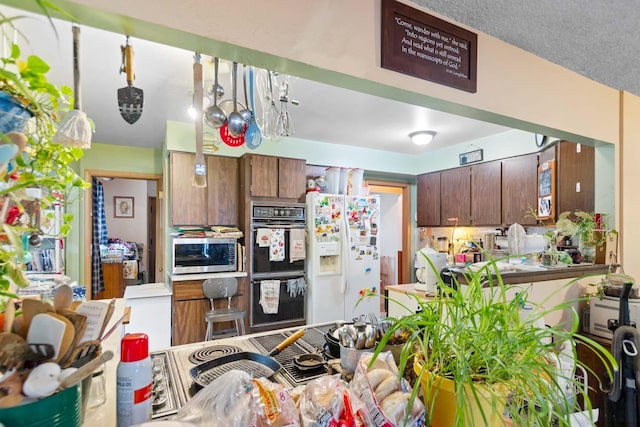 2029 E Sharp Ave, Spokane, WA 99202 - kitchen with white refrigerator with ice dispenser and stainless steel microwave