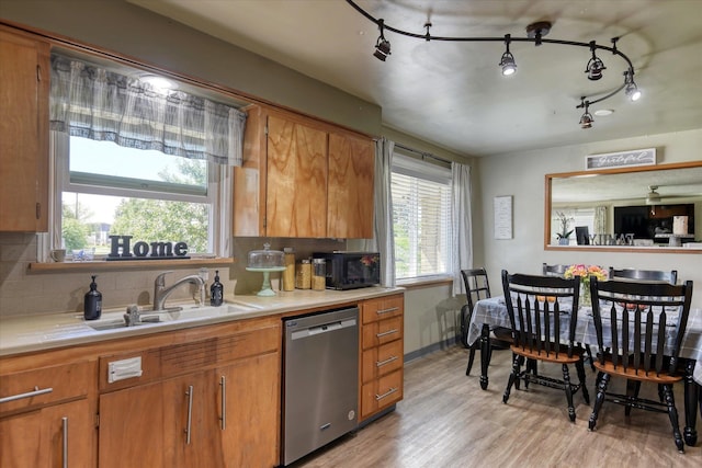 301 E Ermina Ave, Spokane, WA 99207 - kitchen featuring stainless steel dishwasher, a sink, light countertops, and brown cabinetry
