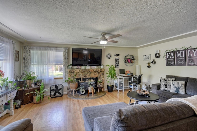 301 E Ermina Ave, Spokane, WA 99207 - living room with a textured ceiling, wood finished floors, a ceiling fan, a stone fireplace, and baseboards