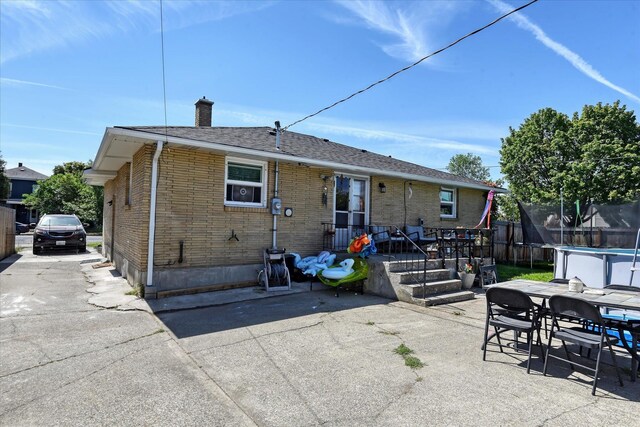 301 E Ermina Ave, Spokane, WA 99207 - back of house with a trampoline, a chimney, a patio, brick siding, and outdoor dining area