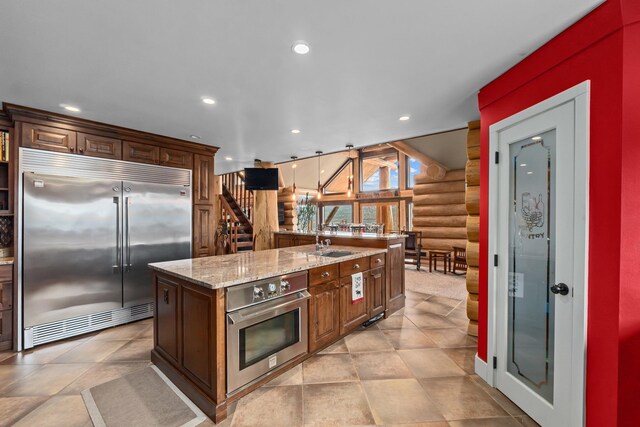 33905 Winterwood Ln Unit E, Davenport, WA 99122 - kitchen featuring stainless steel appliances, recessed lighting, a sink, log walls, and light stone countertops