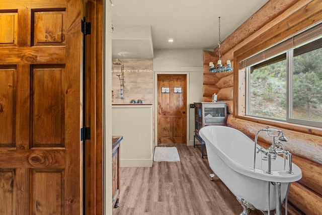 33905 Winterwood Ln Unit E, Davenport, WA 99122 - full bathroom with log walls, a freestanding bath, wood finished floors, and recessed lighting