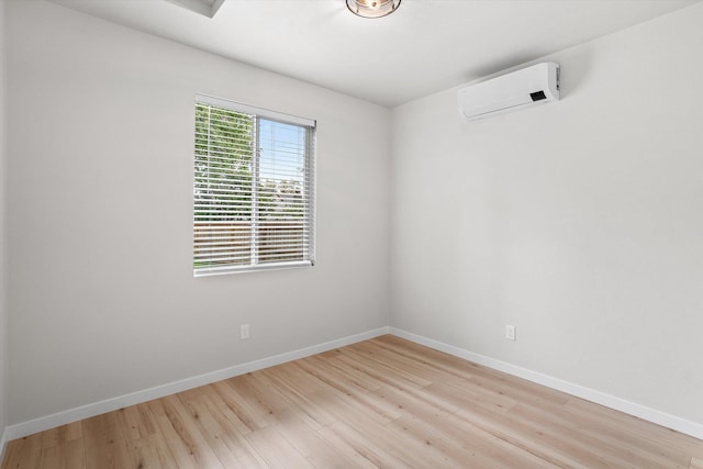 2424 N Addison St, Spokane, WA 99207 - spare room with a wall mounted AC, baseboards, and light wood-style flooring