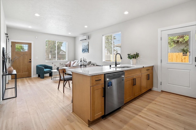 2424 N Addison St, Spokane, WA 99207 - kitchen with stainless steel dishwasher, a sink, a wall mounted air conditioner, open floor plan, and light wood-style floors