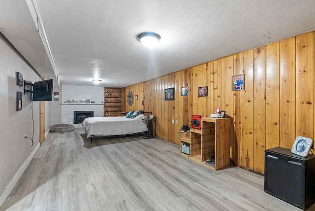 3006 W Francis Ave, Spokane, WA 99205 - bedroom with wood finished floors, a fireplace, wood walls, and a textured ceiling