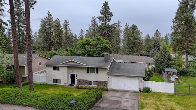1829 S Glenrose Rd, Spokane, WA 99223 - split foyer home featuring an attached garage, concrete driveway, a chimney, a shingled roof, and stone siding