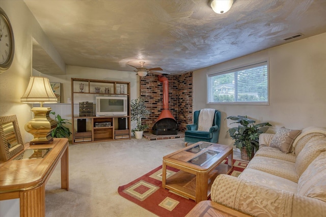 1829 S Glenrose Rd, Spokane, WA 99223 - living area featuring a wood stove, light carpet, and ceiling fan