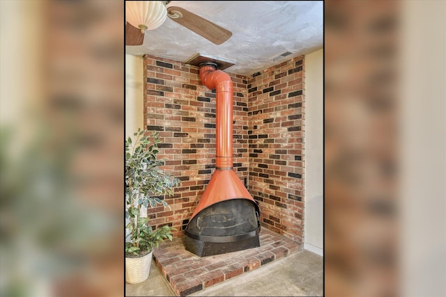 1829 S Glenrose Rd, Spokane, WA 99223 - detailed view of a wood stove, carpet flooring, and ceiling fan