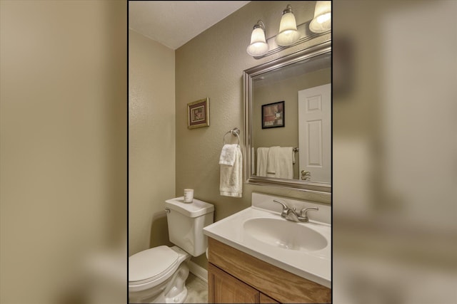 1829 S Glenrose Rd, Spokane, WA 99223 - bathroom with vanity, toilet, a textured wall, and baseboards