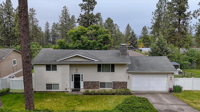 1829 S Glenrose Rd, Spokane, WA 99223 - split foyer home featuring an attached garage, driveway, a chimney, roof with shingles, and stone siding