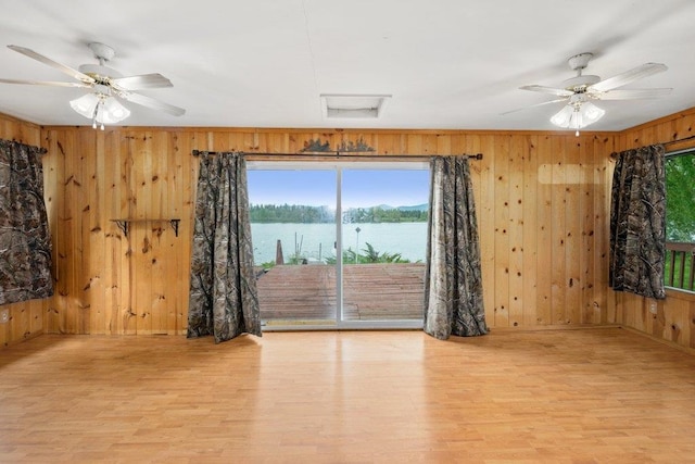 472 Snow Berry Ln, Usk, WA 99180 - spare room with wooden walls, attic access, wood finished floors, a water view, and a ceiling fan