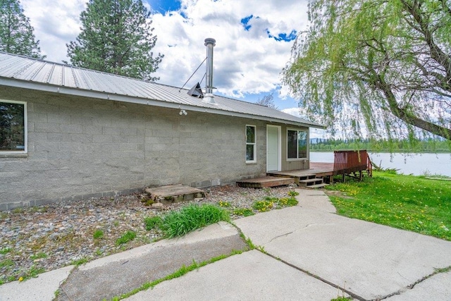 472 Snow Berry Ln, Usk, WA 99180 - rear view of house featuring a wooden deck, a lawn, concrete block siding, and metal roof