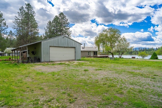 472 Snow Berry Ln, Usk, WA 99180 - view of grassy yard with a detached garage, an outdoor structure, and a water view